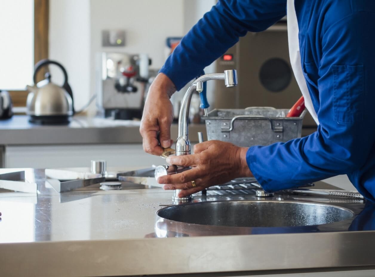 Photo of a plumber fixing the faucet