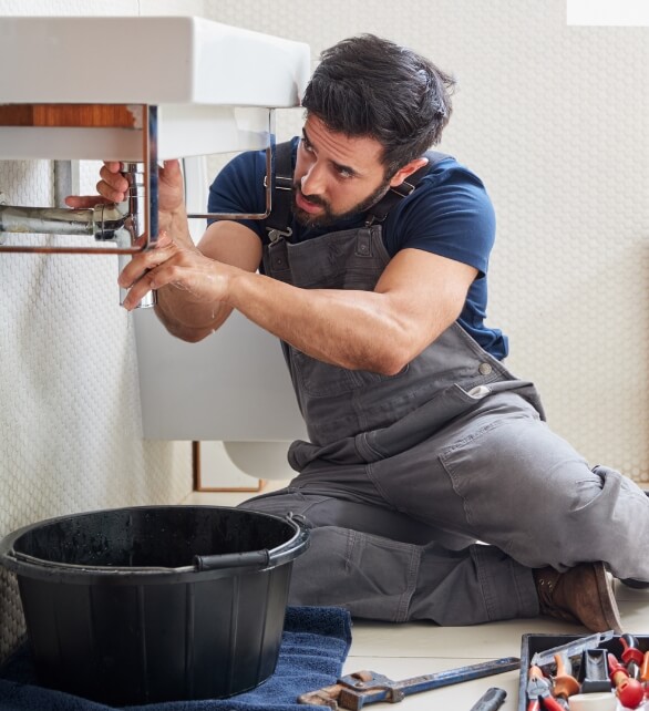 A plumber fixing the bathroom sink
