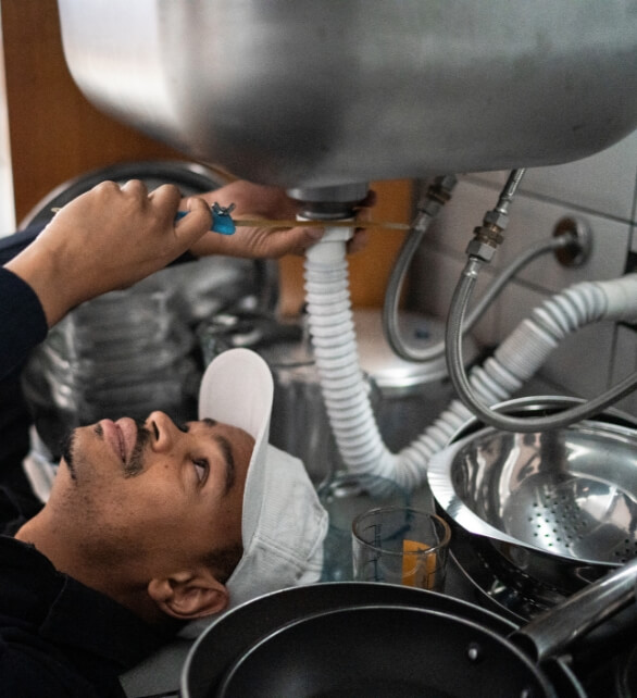 Photo of a plumber fixing the sink pipe