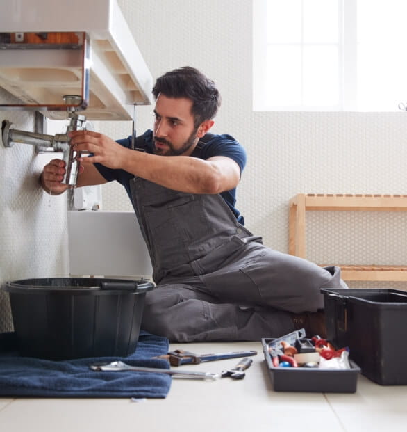 Picture of a plumber fixing the bathroom sink pipe